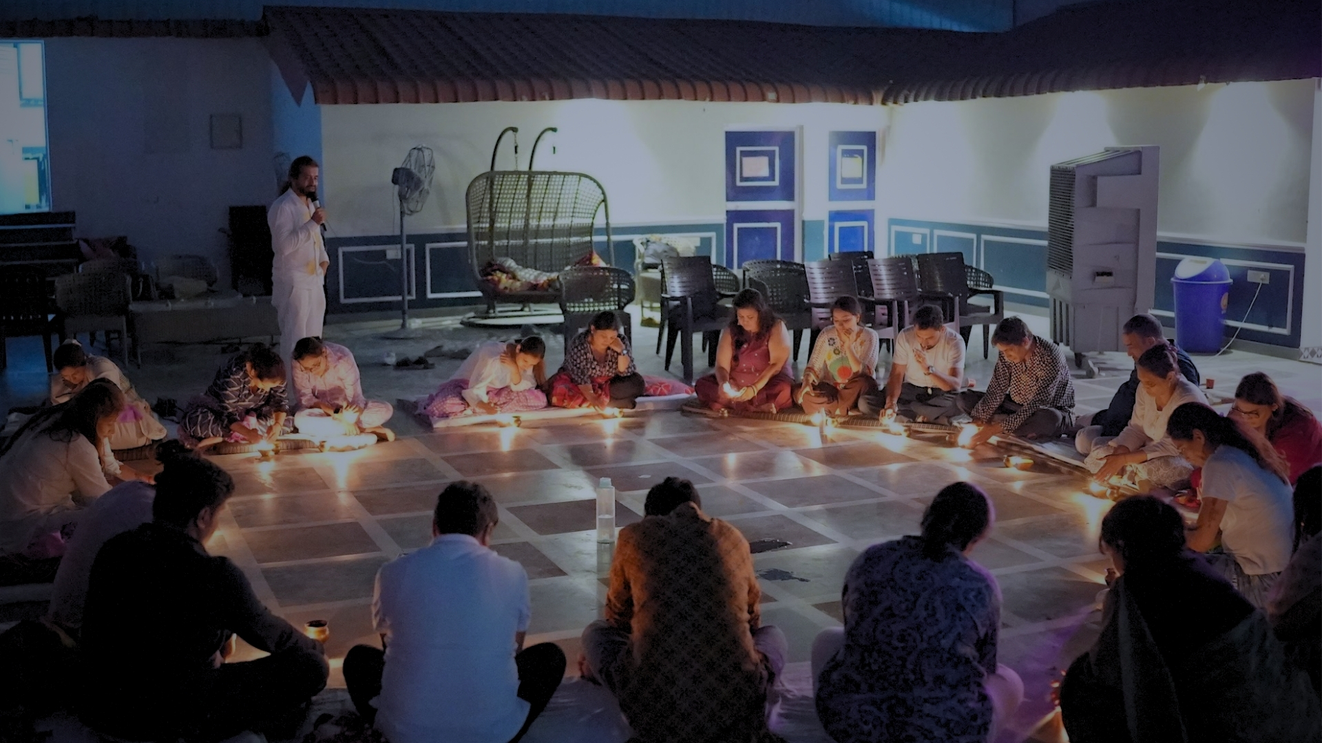 SomRatri guests seated in a candlelit full moon circle